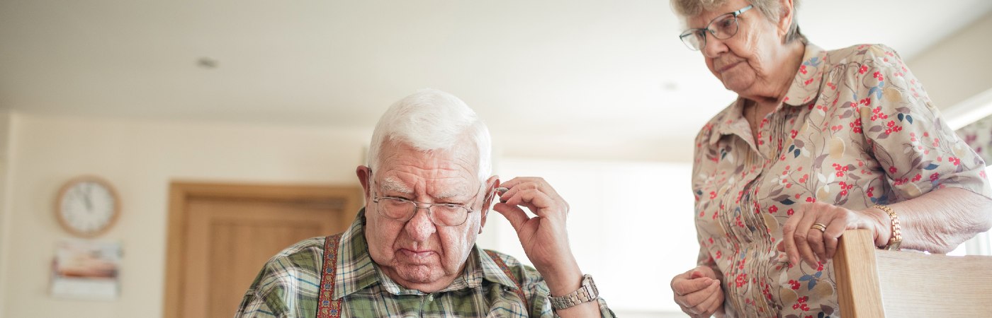 Senior man inserting his hearing aid